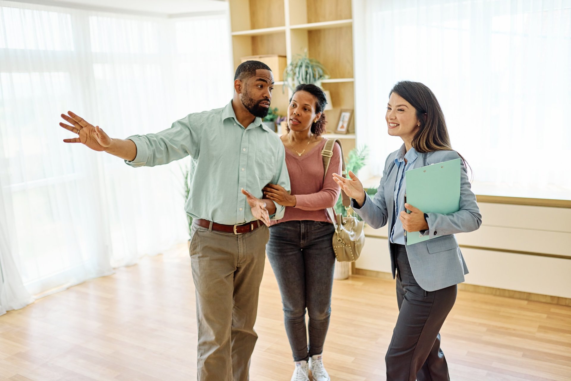 Female Real Estate Agent Showing A Modern Home To Clients